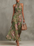 Halter neck floral maxi dress in green botanical print with adjustable neck ties and flowing skirt