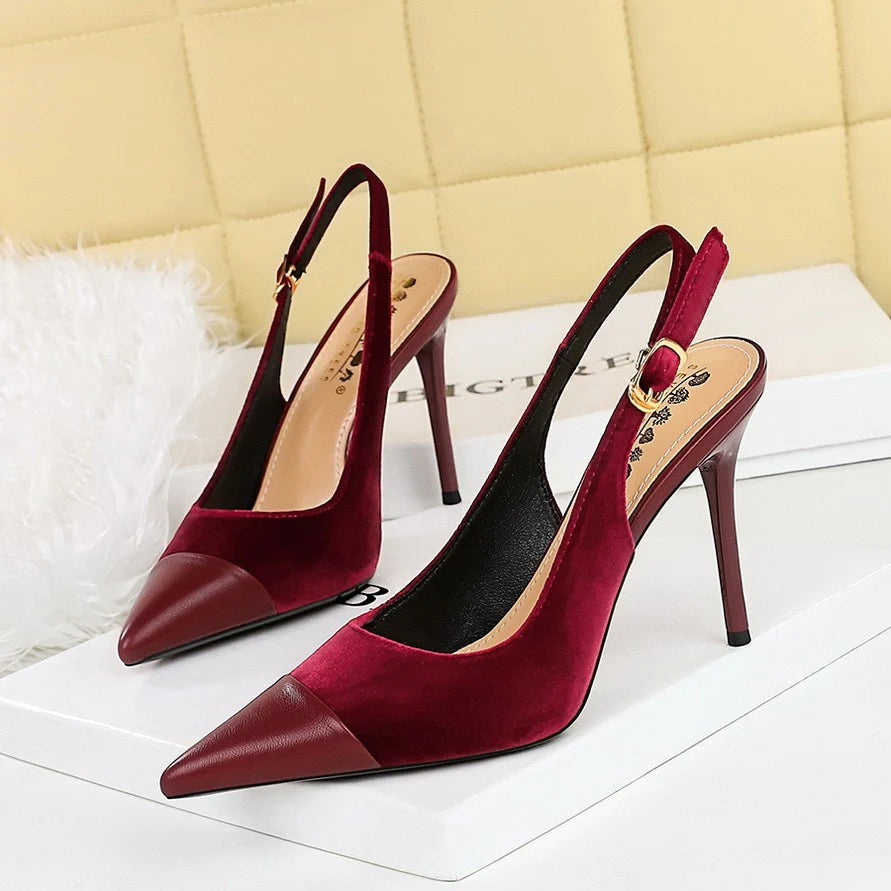 Close-up of pointed toe heels showing contrast cap toe detail and structured upper