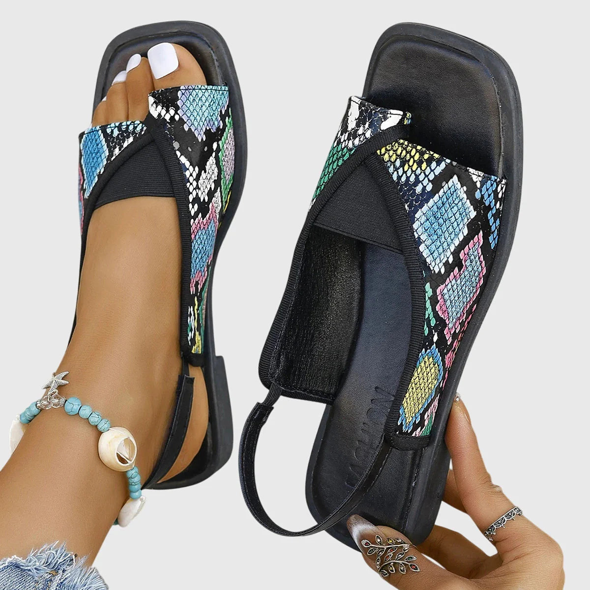 Leopard print women's slingback sandals with toe-loop design and elasticated back strap on outdoor setting