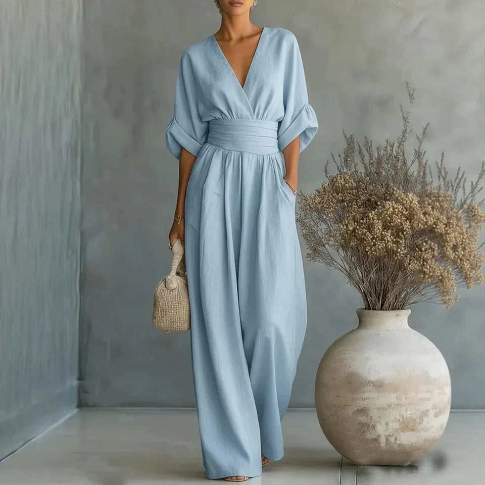 Detail shot of deep V-neckline and pleated waist panel on jumpsuit