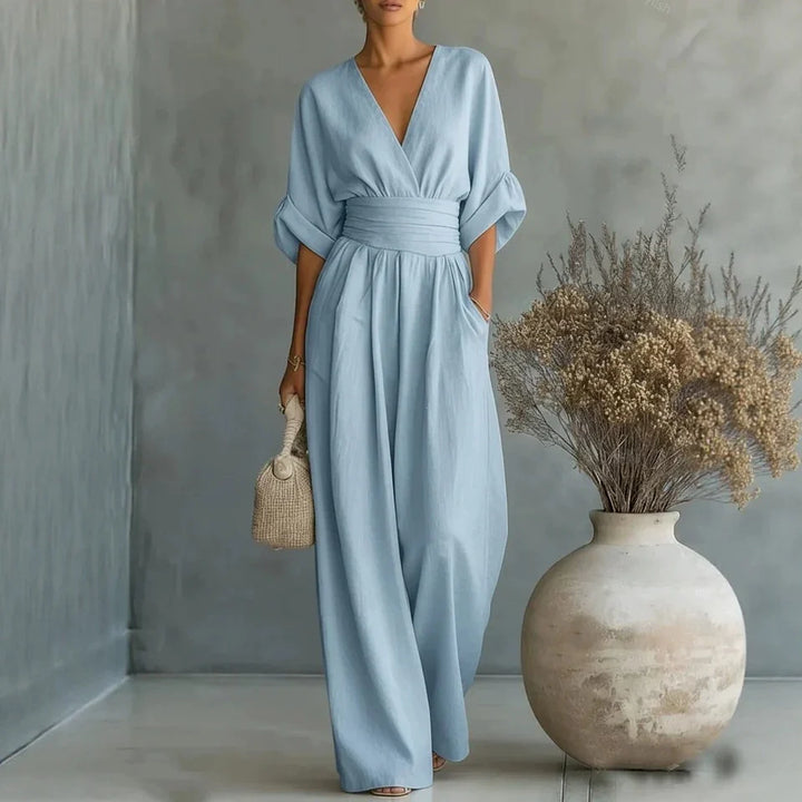 Detail shot of deep V-neckline and pleated waist panel on jumpsuit