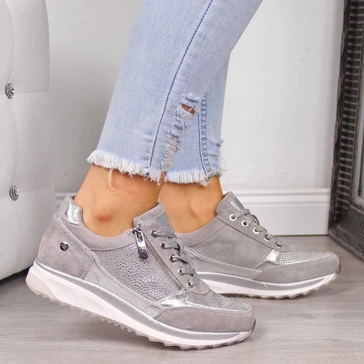 Side view of women's orthopedic zip sneakers showing cushioned sole and structured upper with metallic accents