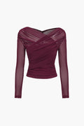 Side view of women's ruched wrap mesh top displaying sheer sleeve construction and sculpted silhouette