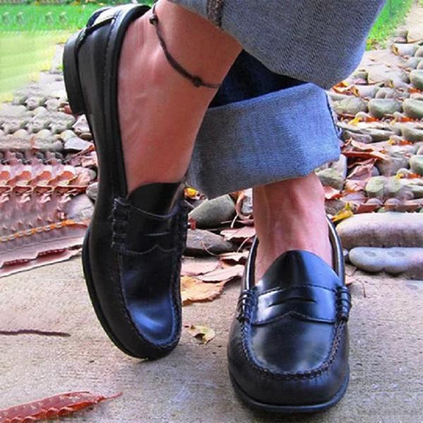 Side view of women's slip-on loafers showing round toe, flat sole, and structured upper with visible stitching