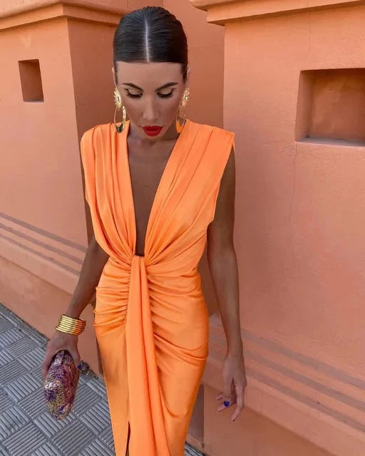 Woman wearing orange draped V-neck midi dress with twist front detail and thigh-high split