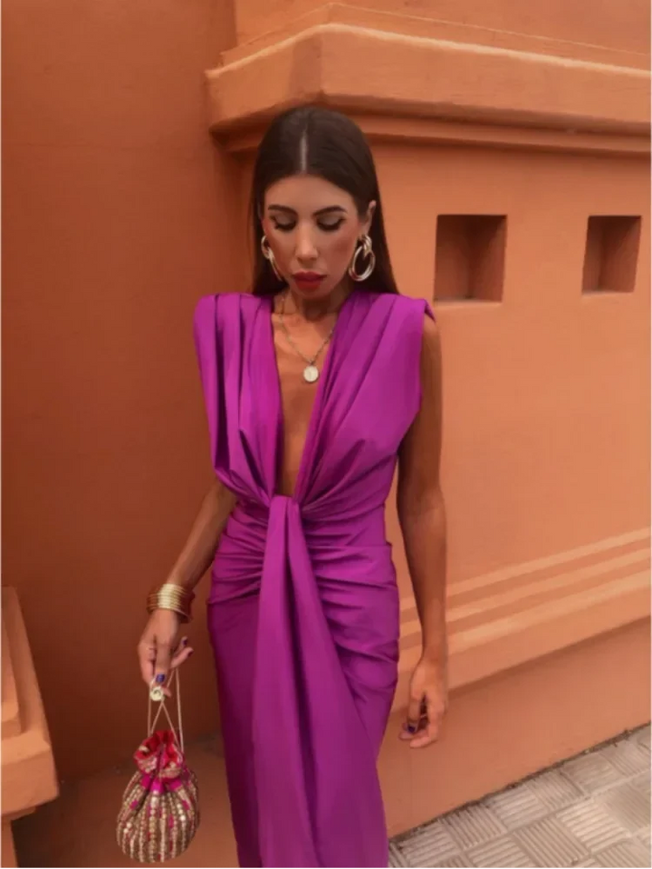 Full-length view of draped midi dress styled with statement earrings for evening occasion