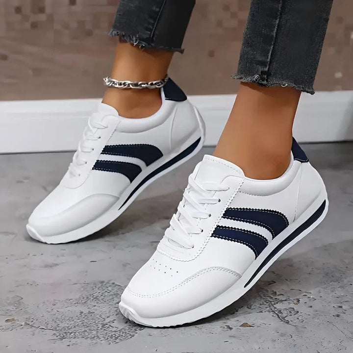 Close-up view of women's lace-up orthopedic trainers showing breathable upper and sporty navy accents