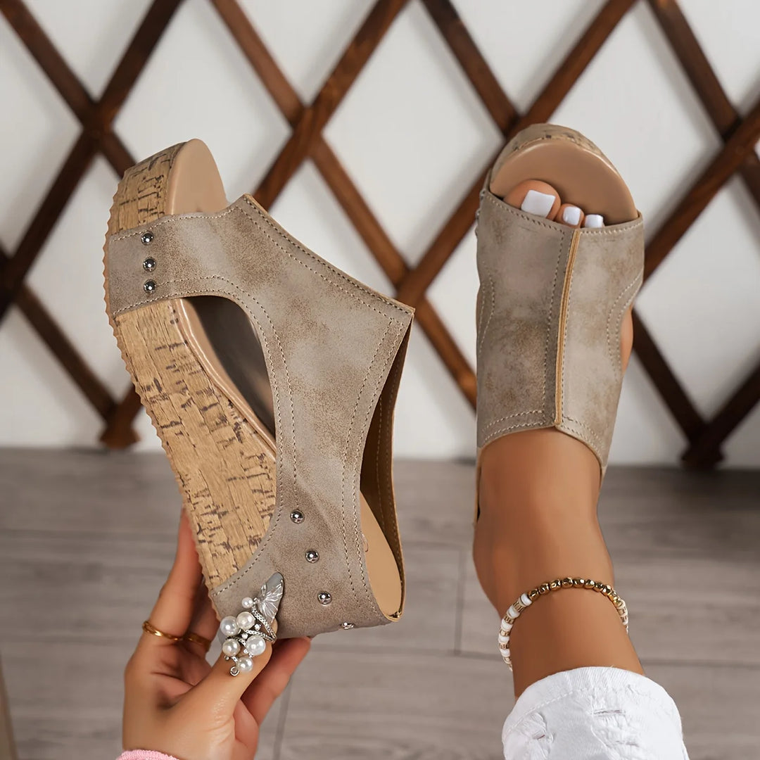 Detail of cork platform wedge sandals with studded footbed and open-toe cutout design
