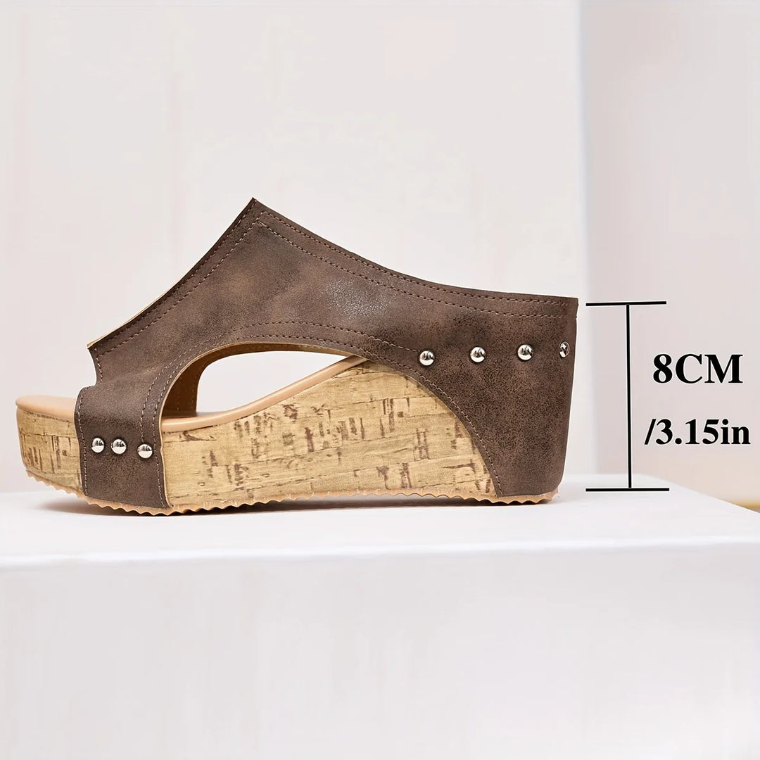 Close-up of women's wedge sandals showing smooth upper finish and decorative stud accents