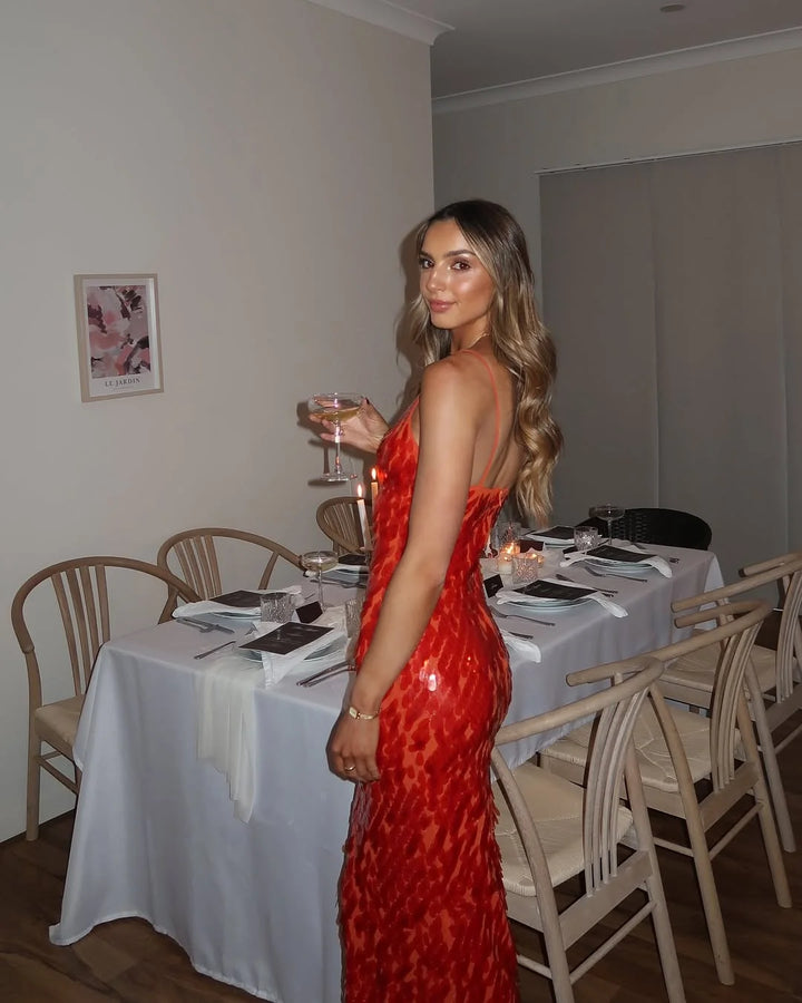 Full-length view of red sequin evening dress with halter neckline and floor-length maxi hem