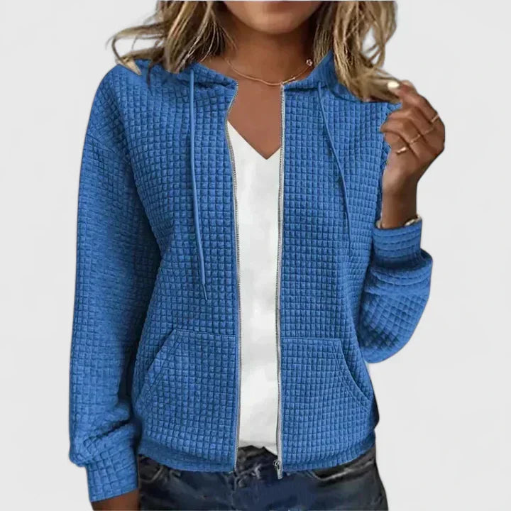 Side angle of women's quilted zip front jacket displaying relaxed fit and long sleeves