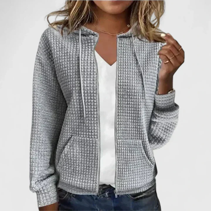 Women's quilted zip front jacket styled with white tee and jeans for casual layering look