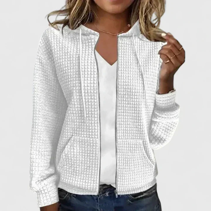 Detail shot of women's quilted zip front jacket highlighting round neckline and front pockets