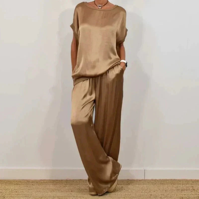 Full length view of wide leg trousers paired with short sleeve top in coordinated neutral tone