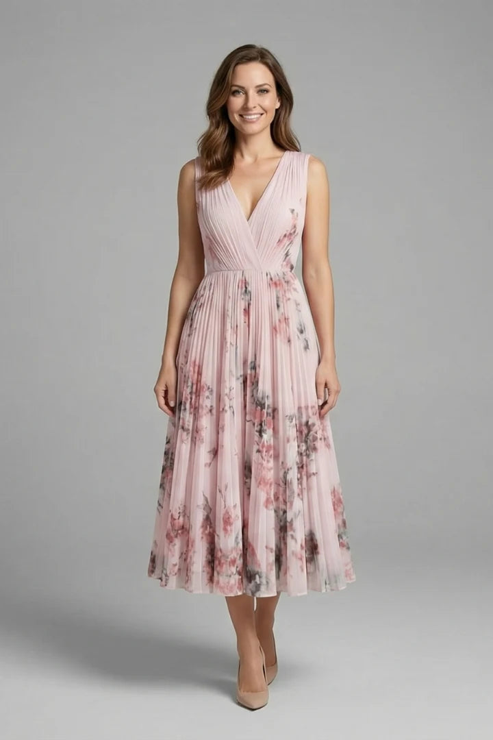 Close-up view of the V-neckline and fitted waist seam on the sleeveless dress with pleated skirt