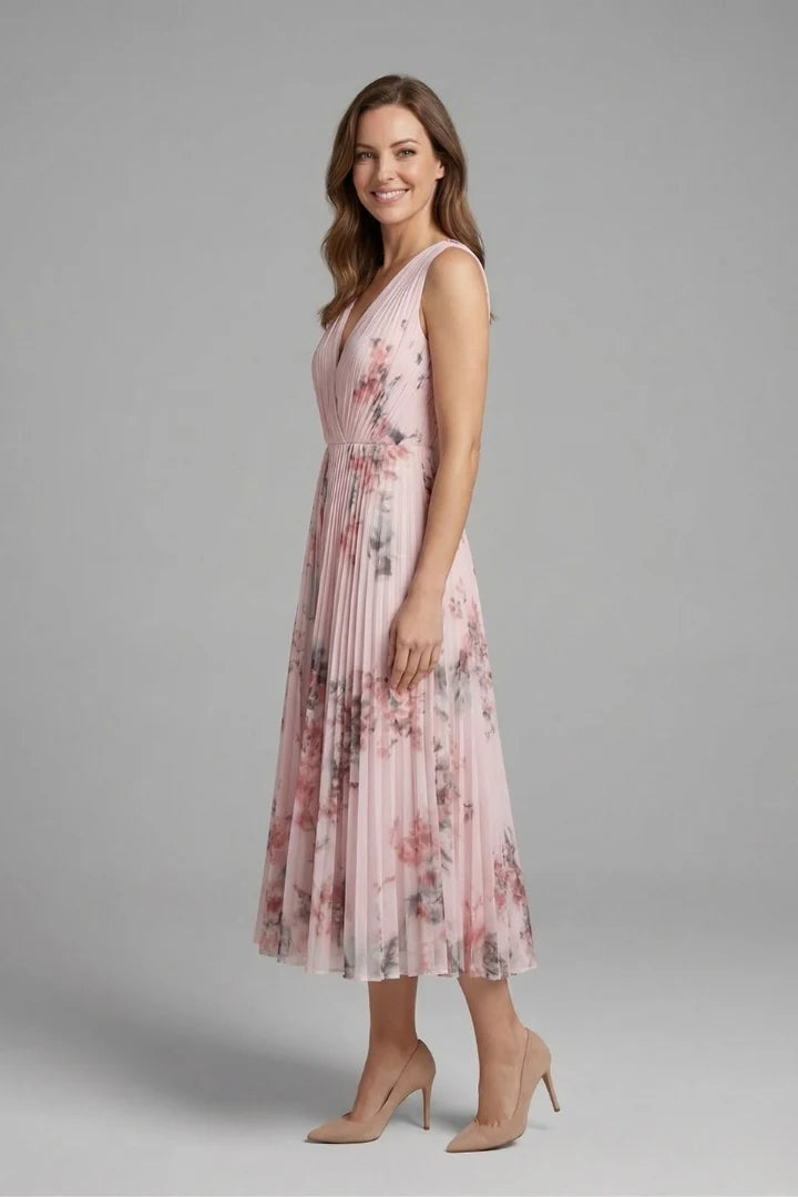 Side angle showing the flared pleated midi skirt and sleeveless bodice of the floral print dress