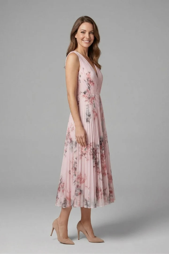 Detail of the vertical pleats and floral pattern on the midi-length skirt of the dress
