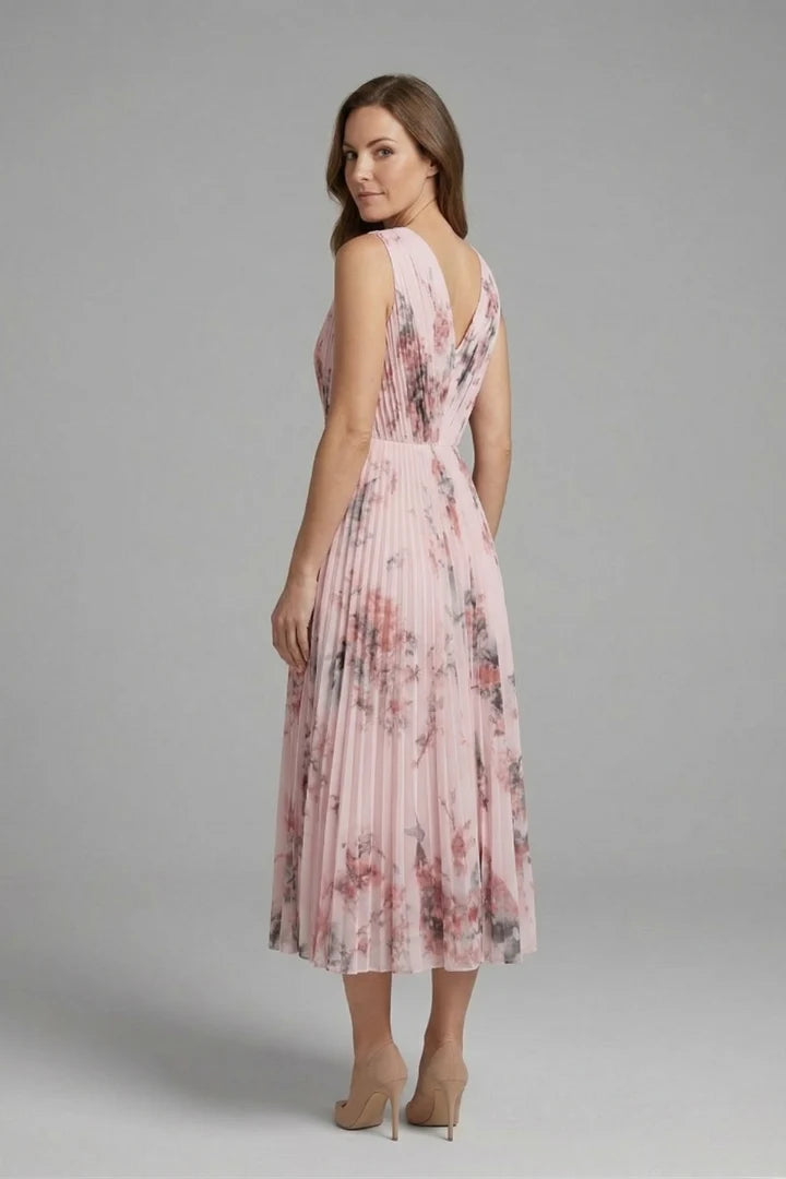 Back view of the sleeveless dress featuring V-neckline and flowing pleated skirt with floral motif