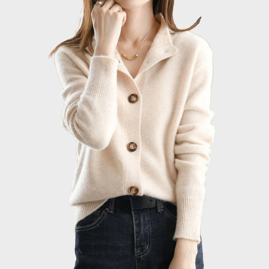 Women's knit cardigan styled over white trousers showing versatile layering options