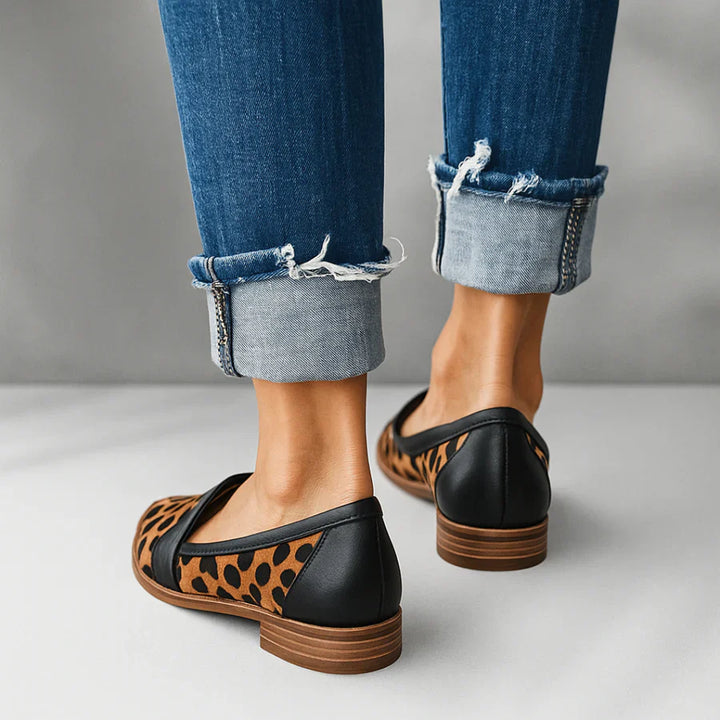 Women's black loafers styled with tailored trousers for office or casual wear