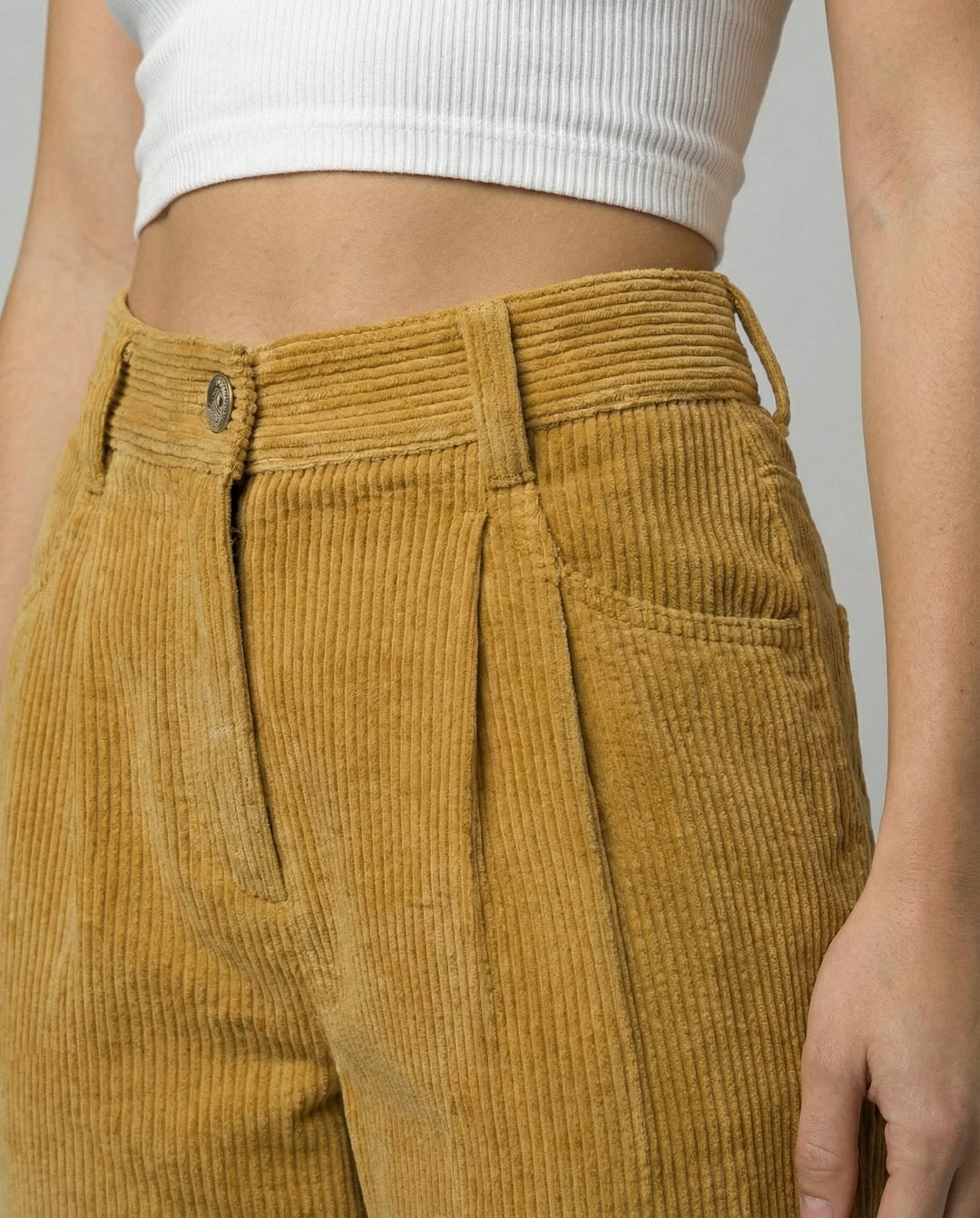Full-length view of relaxed fit corduroy trousers paired with white crop top