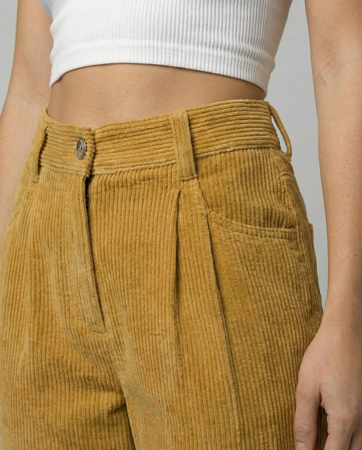Full-length view of relaxed fit corduroy trousers paired with white crop top