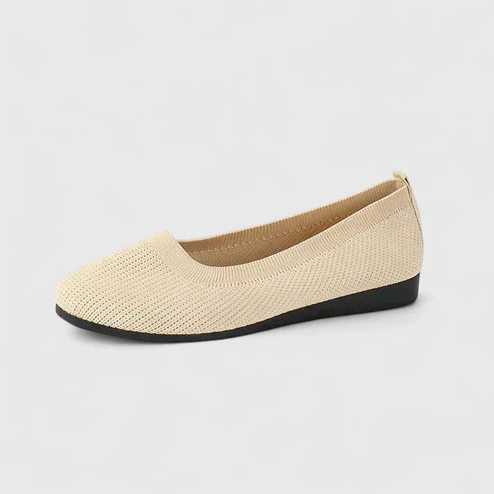 Close-up view of textured black slip-on flats showing structured upper and supportive insole design