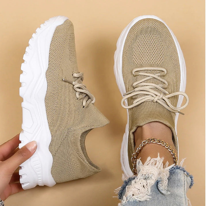Detail shot of white supportive trainers with lace-up front and structured mesh upper for all-day wearability