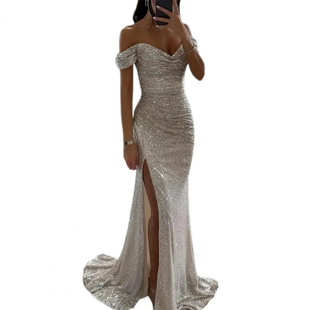 Evening wedding guest dress in sequin fabric with off-shoulder sleeves and high slit detail
