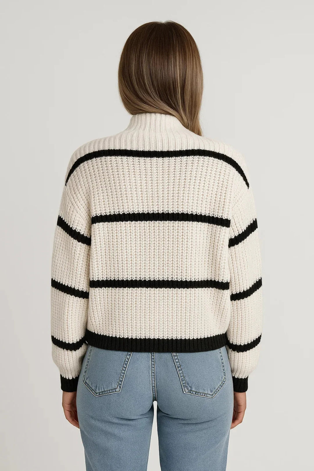 Close-up of women's striped knit jumper showing ribbed texture and contrast cuffs with relaxed fit