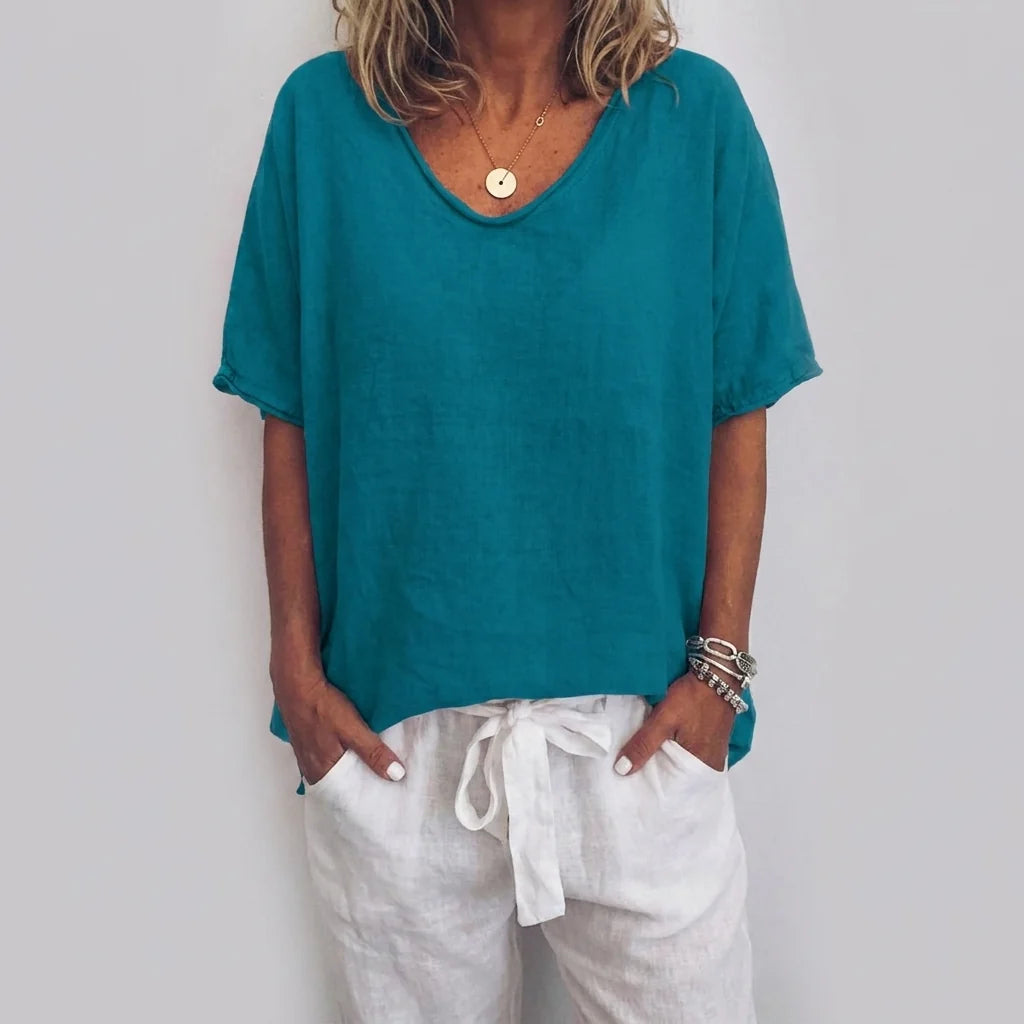 Full-length view of women's grey v-neck tee styled with linen trousers for casual wear