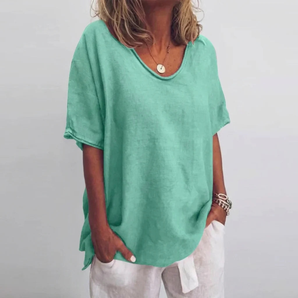 Women's oversized v-neck tee in natural beach setting showing comfortable, breathable fabric
