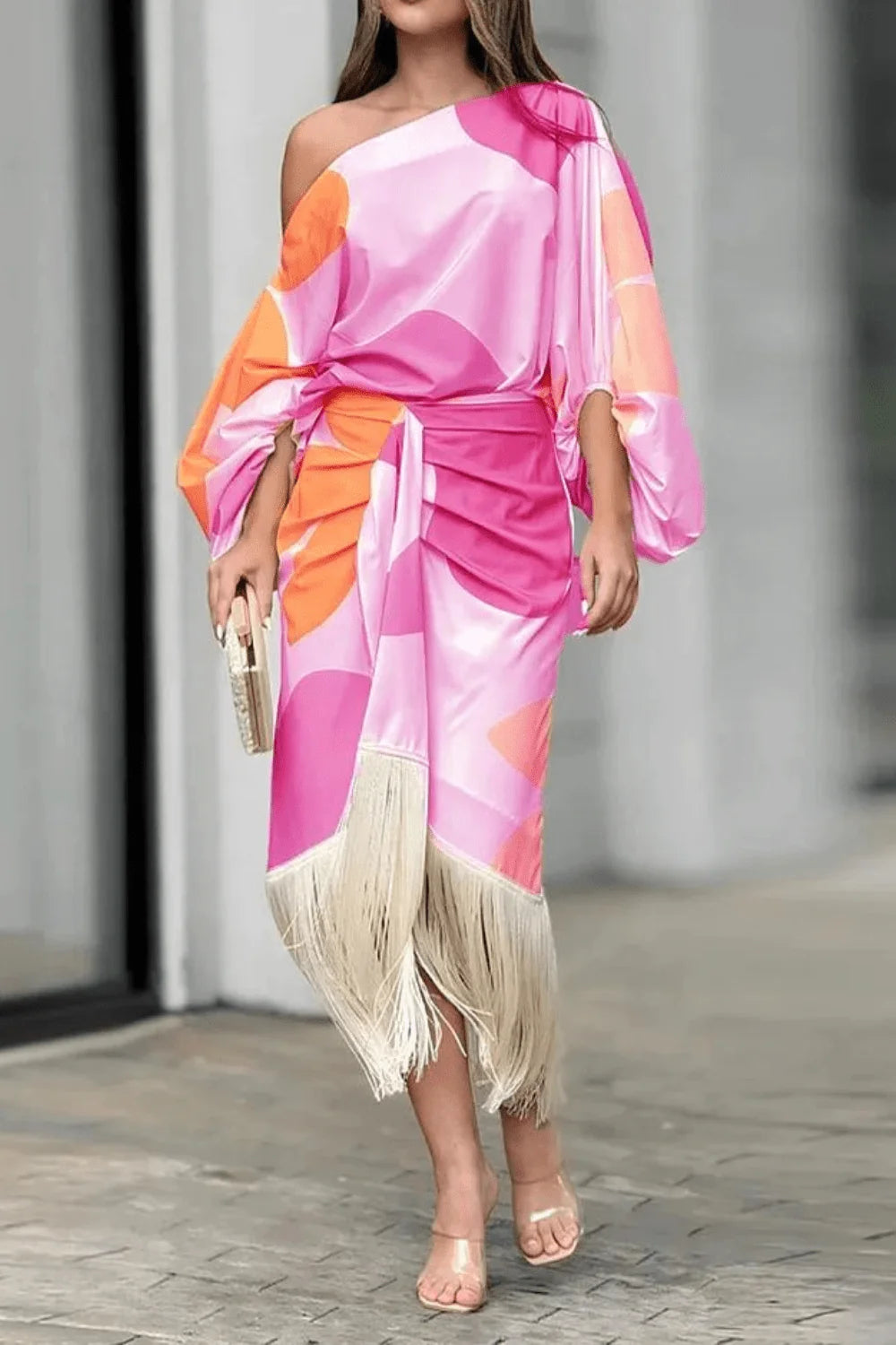Detail of fringe hem on midi-length skirt of one shoulder wrap dress