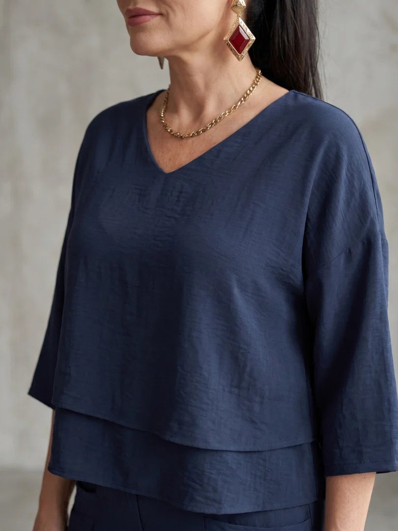 Front view of navy two piece set featuring V-neck layered top and wide leg pants