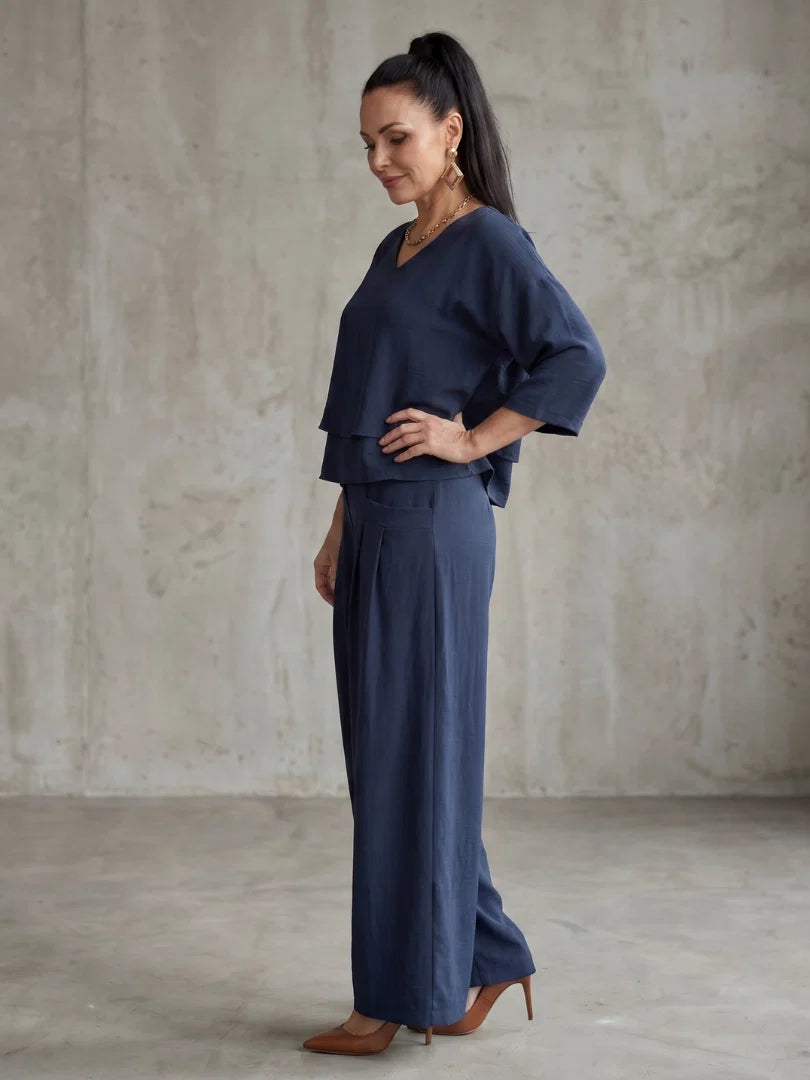 Side angle of women's relaxed fit pants set with tiered overlay top and flowing trousers