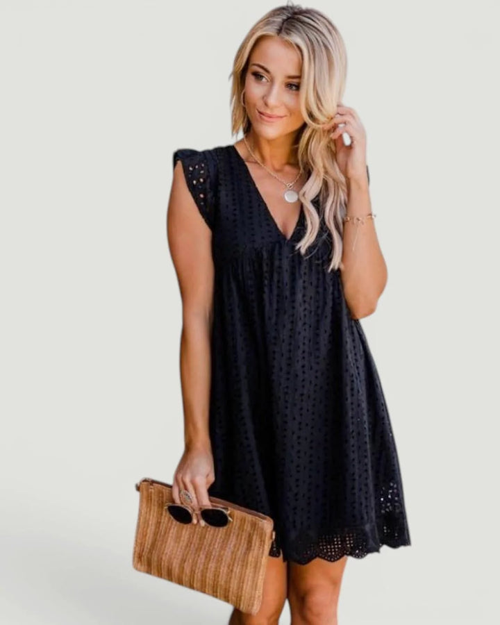 Woman wearing Quinn 2-in-1 dress with built in shorts in black eyelet fabric with V-neckline and relaxed fit