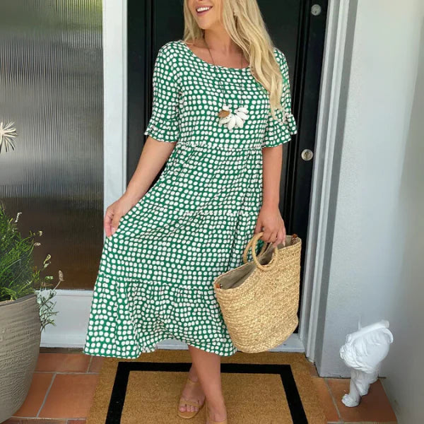 Full length view of polka dot tiered midi dress paired with sandals and woven bag