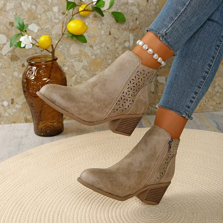 Women's ankle boots cutout detail displayed on textured surface showing construction quality