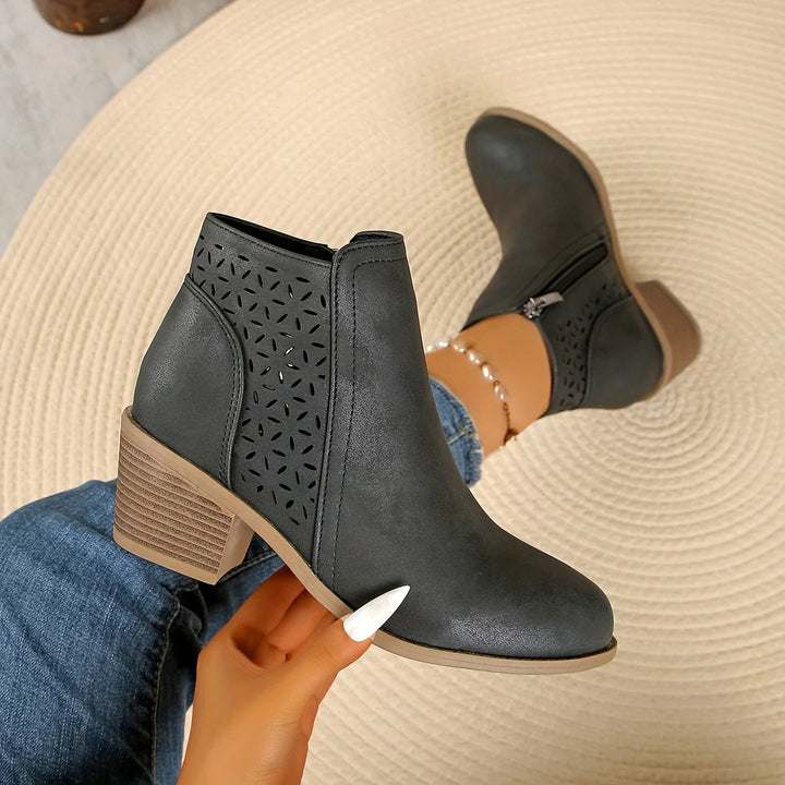Front angle of women's ankle boots featuring perforated shaft and block heel construction