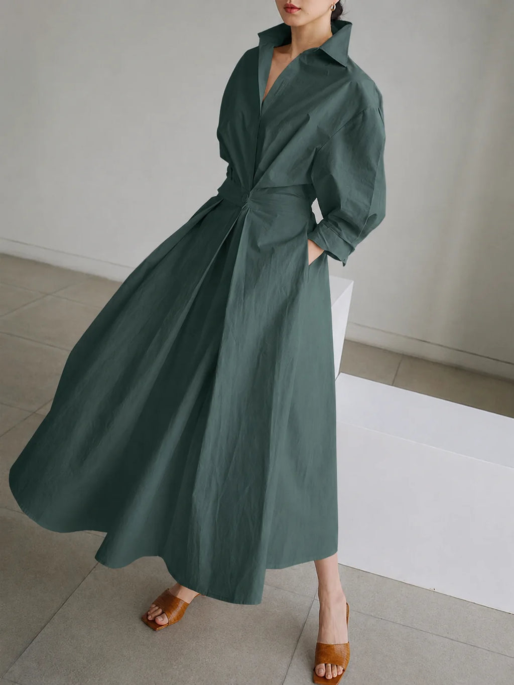 Women's collared A-line midi dress showing pocket detail and flowing hem