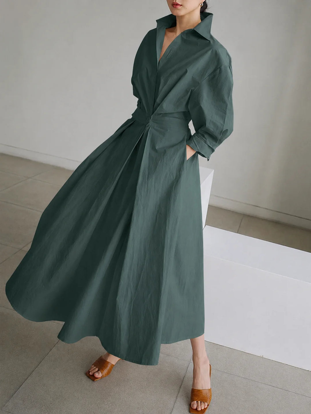 Women's collared A-line midi dress showing pocket detail and flowing hem