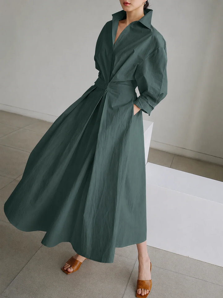Women's collared A-line midi dress showing pocket detail and flowing hem