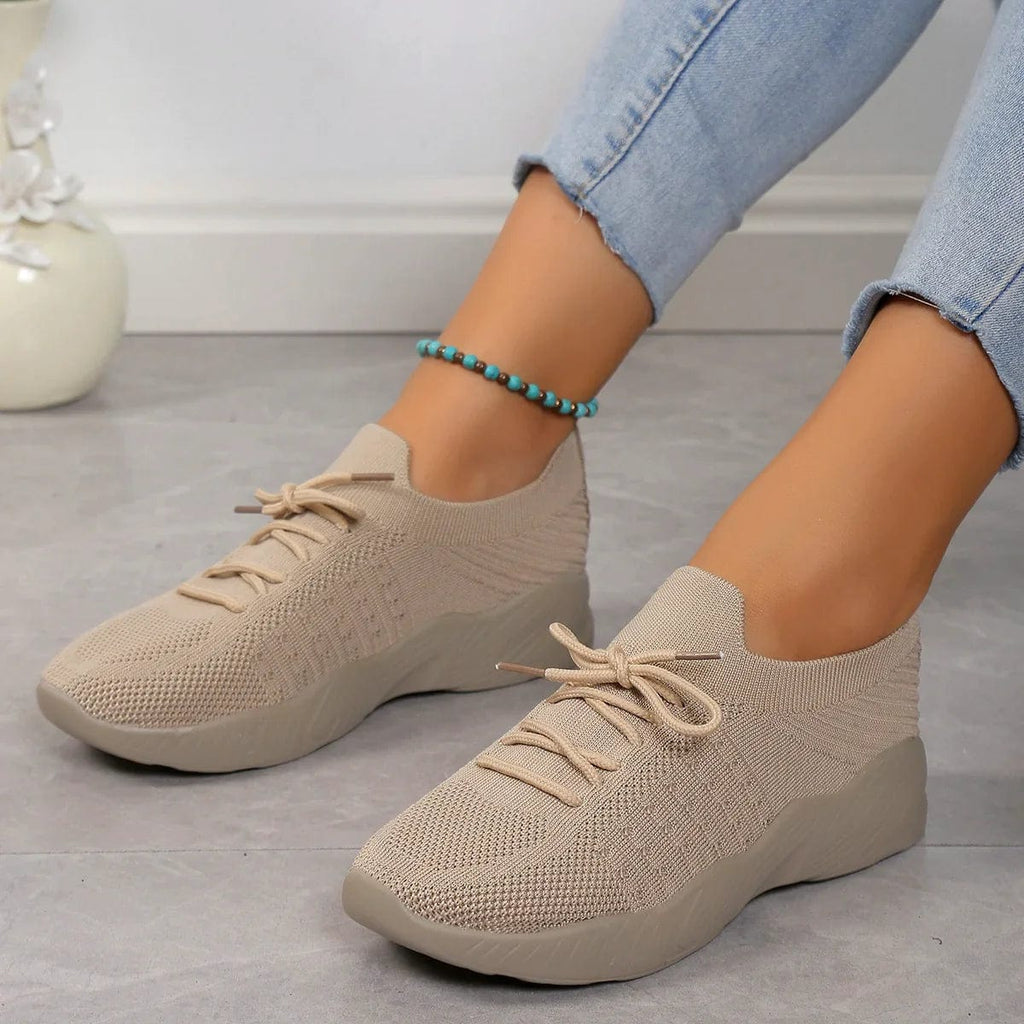 Sky blue lace-up trainers worn with casual outfit showing sock-like fit and flexible construction