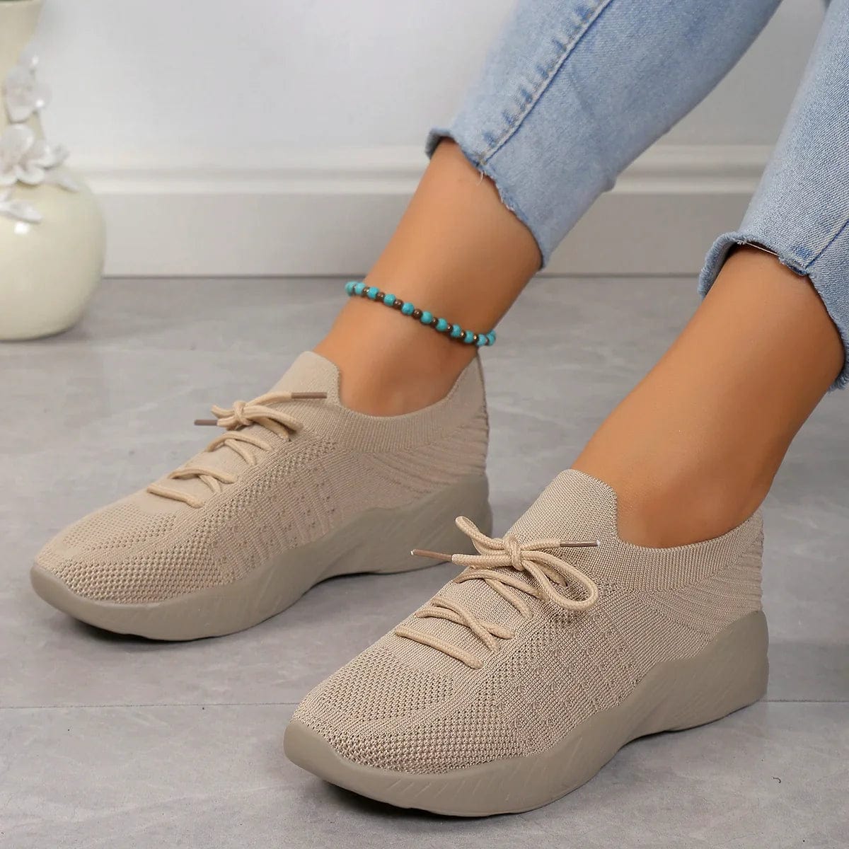 Sky blue lace-up trainers worn with casual outfit showing sock-like fit and flexible construction