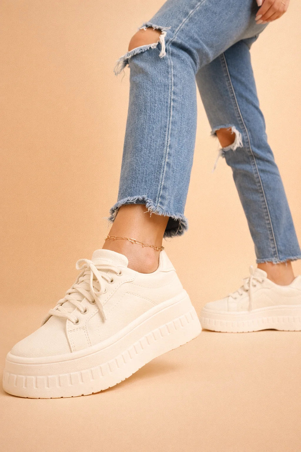 Close-up of platform sneakers for women featuring lace-up closure and smooth tan finish