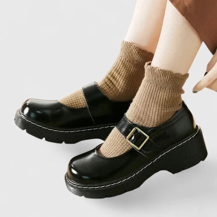 Women's platform Mary Jane shoes in brown showing adjustable buckle strap closure