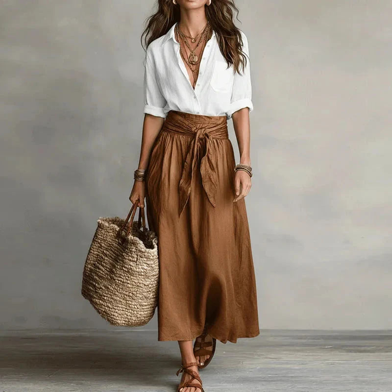 Relaxed button-up shirt paired with flowing midi skirt featuring adjustable waist tie detail