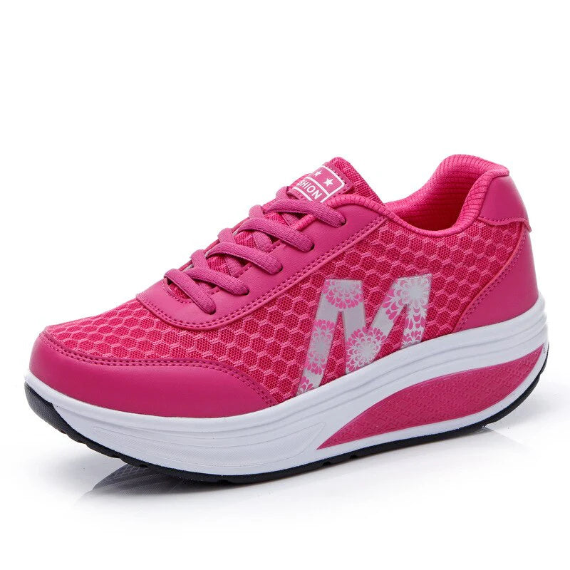Side view of orthopedic walking sneakers showing curved rocker sole and pink accent detail